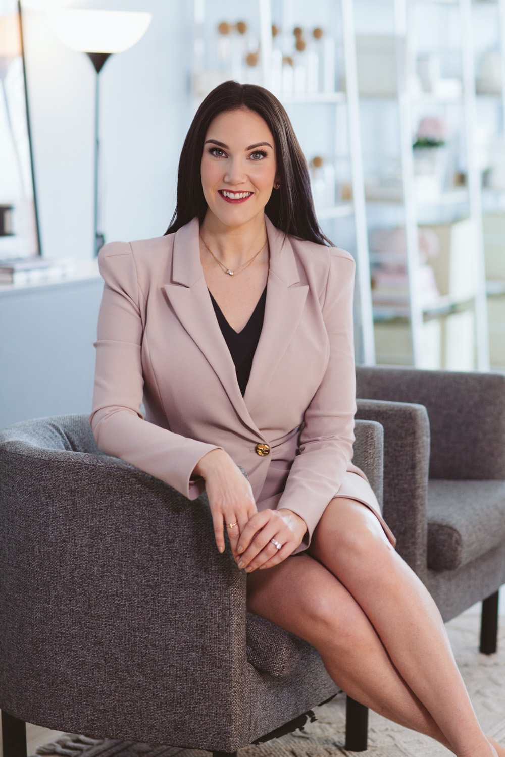 Victoria in a light suit sat on a sofa